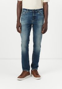 Jeans slim fit de culoare albastră, realizate din denim, având un finisaj uzat, design cu cinci buzunare și o închidere clasică cu nasture și fermoar.