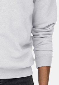 Lichtgrijze sweatshirt met een geribbelde halslijn en boorden, gemaakt van een zachte katoenmix, met een gladde textuur en een relaxte pasvorm.