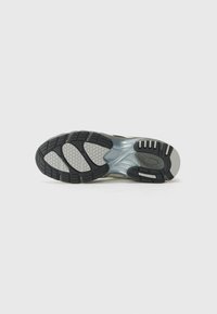 Semelle de chaussure de course en caoutchouc noir texturé avec des accents gris et une semelle intermédiaire semi-transparente ; motif de traction distinct visible.