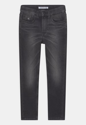 Jeans negros ajustados con cinco bolsillos, detalles desteñidos en la parte delantera, trabillas para cinturón y un logo de Calvin Klein en el pequeño bolsillo delantero y en la cintura.