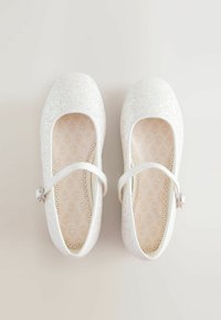 Ballerine bianche glitter con punta rotonda, suola piatta e una fascia alla caviglia. All'interno presentano un motivo a foglie su uno sfondo beige.