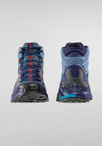 Wysokie buty trekkingowe w kolorze niebieskim i granatowym z czerwonymi akcentami. Teksturowana górna część z materiału, wyś padded kołnierz oraz gumowa podeszwa z wzorami zwiększającymi przyczepność.