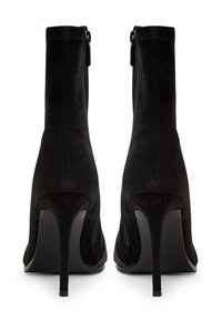 Bottes de cheville en suede noir avec un talon aiguille haut, fermeture éclair à l'arrière, et une texture lisse, arborant un design sans couture et une silhouette épurée.