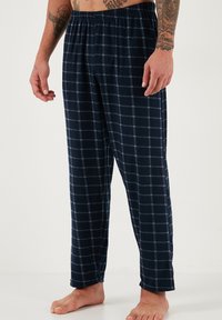 Pamučne pidžama hlače s mornarsko plavim kariranim uzorkom, izrađene od mekane tkanine, s elastičnim pojasom i širokim krojem, s bijelim i svijetloplavim kvadratima.