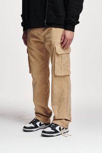 Lichtbruine corduroy cargobroek met grote zijzakken, gedragen met zwart-witte sportschoenen, met een losse pasvorm.