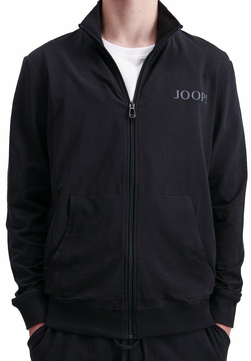 Schwarze Zip-Jacke aus weichem Stoff, mit hohem Kragen, zwei Fronttaschen und einem kleinen Logo auf der linken Brust.