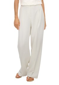 Szerokie spodnie wykonane z miękkiego białego materiału o gładkiej fakturze i plisowanym przodzie. Ubranie ma wysoki stan i boczne kieszenie.