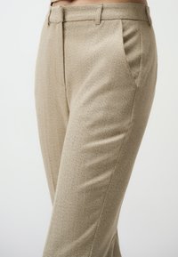 Beige Hahnentritt-Hosen mit taillierter Passform, mit Fronttaschen, gefalteten Beinen und einem glatten, strukturierten Stoff.