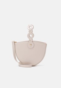 Beige half-moon bag made of smooth material, featuring a circular handle with cut-outs and a detachable shoulder strap. Gold hardware accents.
