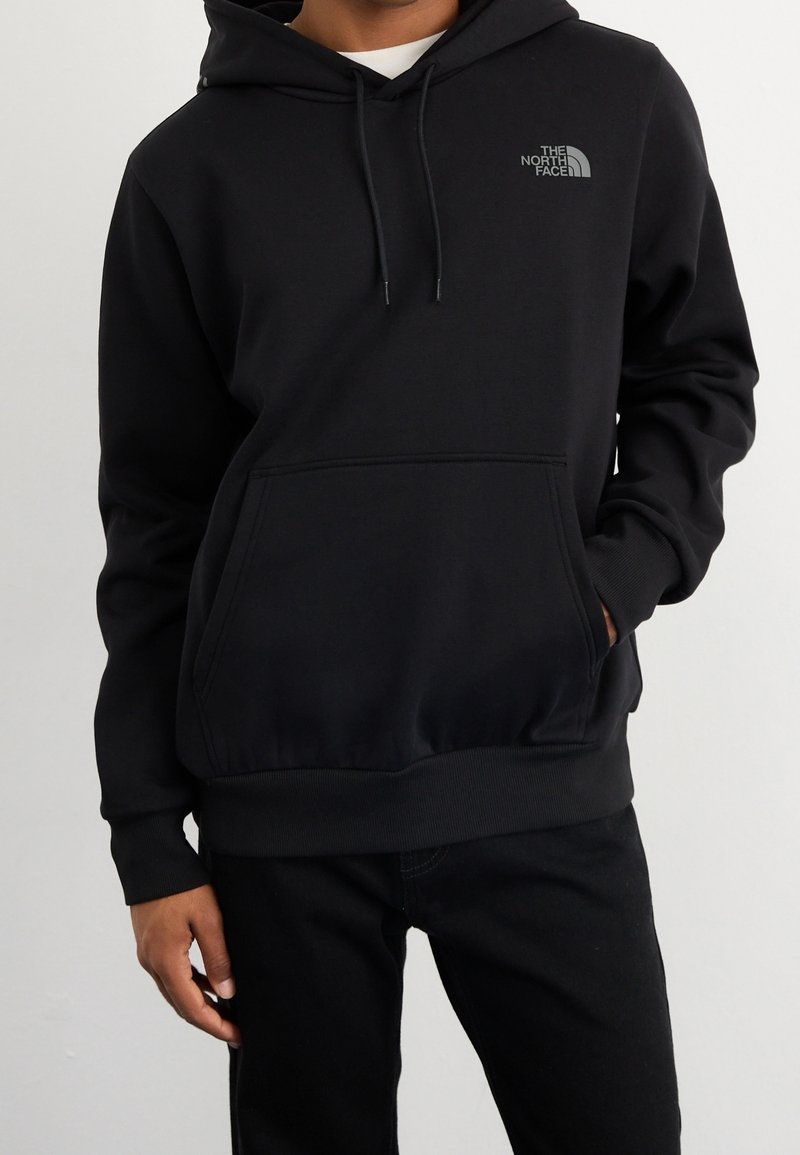 Zwarte hoodie gemaakt van zachte stof, met een voorzak in kangoeroe-stijl en een klein grijs logo op de borst. Eenvoudige geribbelde boorden en zoom.