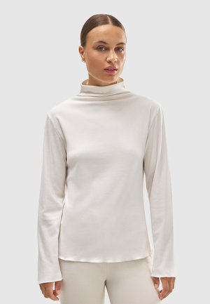 Top de manga larga con cuello alto en suave tejido blanco de textura lisa. Presenta un corte relajado y un bajo recto sencillo.