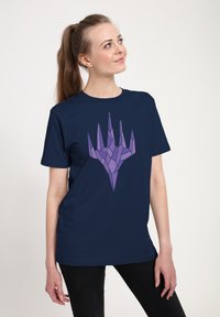 Námořnické tričko s fialovým geometrickým potiskem ruky. Krátké rukávy, kulatý výstřih, hladká tkanina a volný střih.
