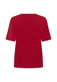Raudona medvilninė marškinėlė trumpomis rankovėmis, su apvaliu iškirpimu ir tiesiu kirpimu. Lygus paviršius, be matomų raštų ar papuošimų.