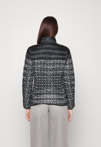 Svart pufferjacka med hög krage, solid övre del och logomönster på den nedre halvan. Lättviktsmaterial med en slät textur.