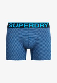 Niebieskie, paskowane bokserki wykonane z miękkiego materiału, z czarnym paskiem w talii z napisem "SUPERDRY" w jasnoniebieskim kolorze.