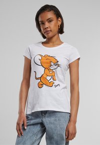 Witte katoenen t-shirt met een cartoonfiguur in oranje, met zwarte contouren. Korte mouwen en ronde halslijn, gestyled met een ontspannen pasvorm.