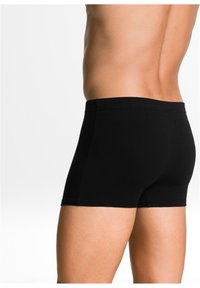 Boxer da uomo in cotone nero con vestibilità aderente, dotati di una cintura liscia e bordi senza cuciture per comfort e supporto.