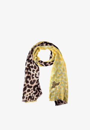 Szalik z podwójnym wzorem w panterkę: jedna strona czarno-biała, druga żółta z jasnymi żółtymi plamkami, z małym nadrukowanym tekstem na żółtej stronie.