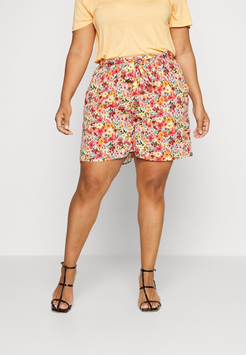 Des shorts fleuris en tissu léger présentent un mélange de teintes roses, jaunes et vertes, avec une taille élastique et un détail de lien à l'avant.