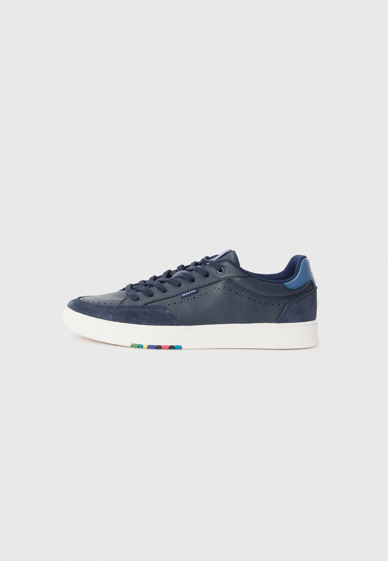 Mörkblå sneaker med övre i läder och mocka, med perforerade detaljer, platta snören och en vit sula med färgade accenter på hälen.