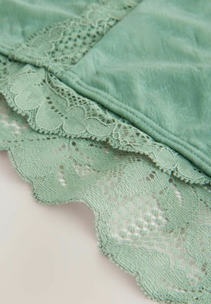 Mintgrön tyg med delikat spetskant som har en scalloped edge och intrikata blommönster, som förenar textur och mjukhet.