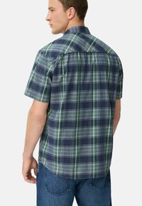 Korte mouwen geruite shirt in groen en marineblauw, gemaakt van zachte katoen. Heeft een button-down kraag en een afgeronde zoom met contrasterende stiksels.