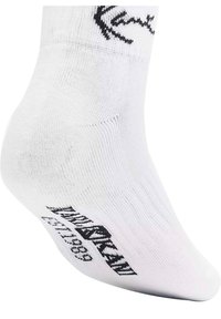 Fehér sportzokni, fekete kötött logóval és fekete felirattal a talpon. Simaság jellemzi, és bokáig érő kialakítással rendelkezik.