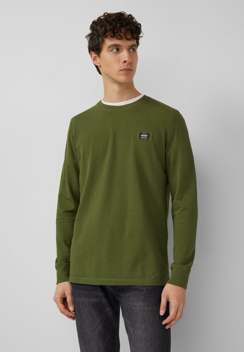 Sipelga-roheline, pikakäistega T-särk tekstuurse kangaga, ümar kaelusega ja väikese logomärgiga rinnal.