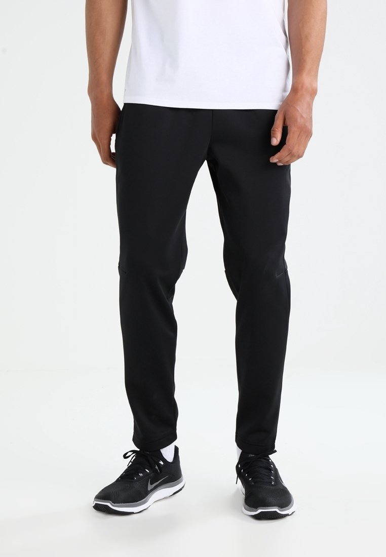 Black athletic pants with a slim fit, made of lightweight material. Features subtle seam details and paired with black athletic shoes.
