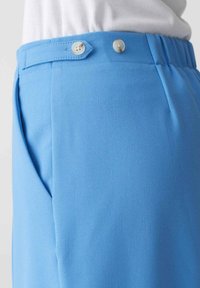 Blauwe broek met een gladde textuur, voorzien van een tailleband met twee knopen, zijzakken en een getailleerde pasvorm.