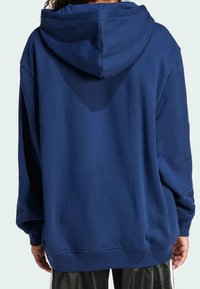Sudadera azul marino con una capucha grande, corte relajado, puños y dobladillo acanalados, y textura suave. Sin logotipos o adornos visibles.