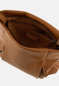 Sac à main en cuir marron avec une finition texturée. Il dispose d'un intérieur spacieux avec une poche zippée et une étiquette en cuir de marque.