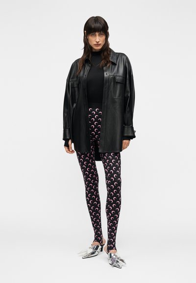 Μαύρο δερμάτινο πουκάμισο-μπουφάν σε μεγάλο μέγεθος, μαύρο κορμάκι, κολάν με σχέδια ροζ μορφής μισοφέγγαρου και ασημένια μυτερά παπούτσια.