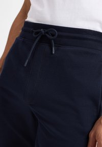 Navyblaue Sweatpants aus Baumwollmix. Mit einem Kordelzugbund, Seitentaschen, glatter Textur und gestickten Details.