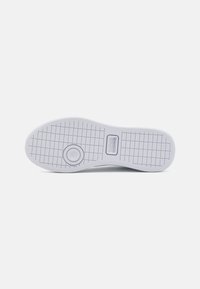 Lacoste sneakersula, vit gummi, strukturerat greppm�önster, rund tå, cirkulär logotypdetalj nära hälen, släta kanter, minimalistisk design.