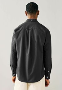 Schwarzes Langarmhemd mit einem Button-Down-Kragen, geradem Rückensteg und Knopfmanschetten. Glattes Material mit einem subtilen Glanz.