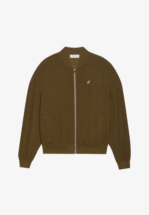 Tamsiai žalia užtrauktukinė striukė, pagaminta iš tekstūruotos medžiagos, su kanalėlių apykakle, rankogaliais ir apačia, ant krūtinės esanti maža auksinė logo.