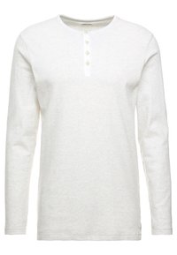 Biała koszulka henley z długim rękawem, wykonana z teksturowanej tkaniny, z okrągłym dekoltem i czterema guzikami w beżowym kolorze.