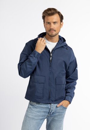 Marineblauwe hoodie gemaakt van glanzend materiaal, met een rits aan de voorkant, twee opgestikte zakken en elastische manchetten. Minimalistisch ontwerp met eenvoudige accenten.