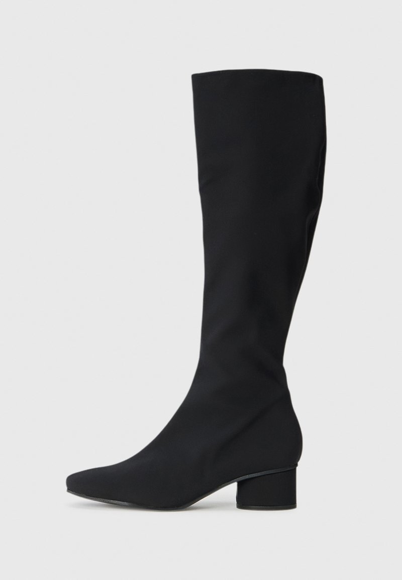 Botas pretas até ao joelho feitas de um material suave, com bico pontiagudo e salto robusto. Design elegante sem padrões ou detalhes visíveis.