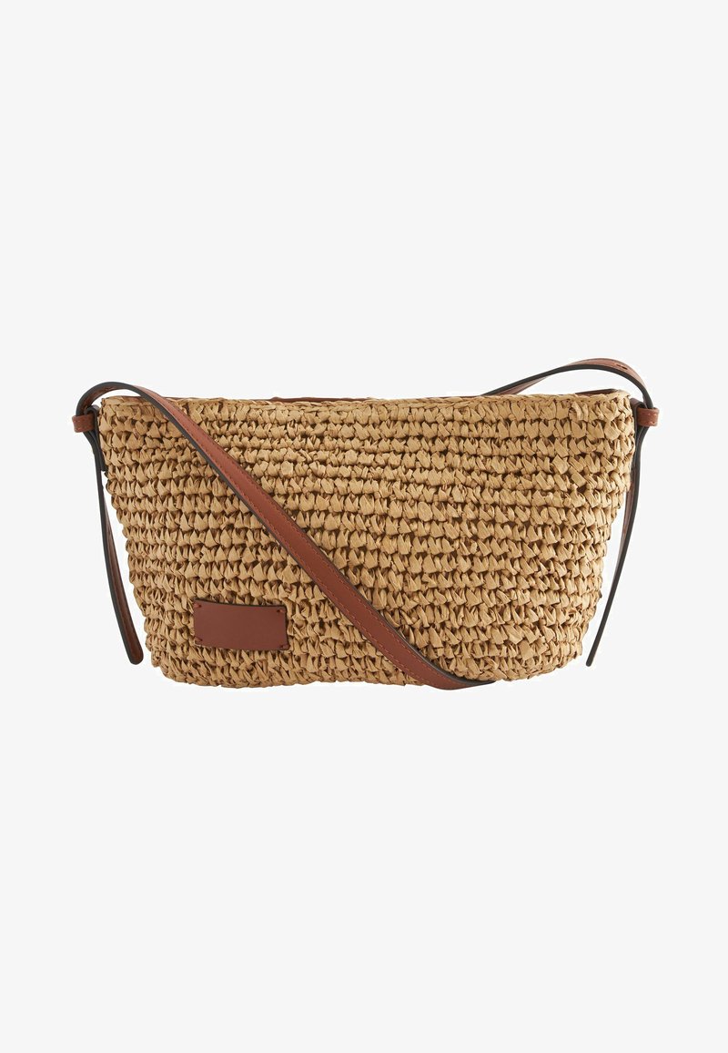 Borsa a tracolla in paglia intrecciata con una forma curva, tracolla in pelle marrone e un piccolo accento rettangolare in pelle sul lato.