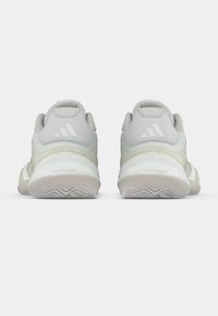 Αθλητικά παπούτσια ανοιχτού γκρι χρώματος με υφαντό διχτυωτό επάνω μέρος, επενδεδυμένο γύρο και λευκή λαστιχένια σόλα. Διαθέτουν το λογότυπο της Adidas στη φτέρνα.