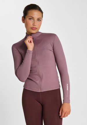 Langärmliges, zip-up Oberteil aus geripptem mauvefarbenem Stoff mit hohem Kragen und schmaler Passform. Logo in Weiß auf dem Ärmel aufgedruckt.