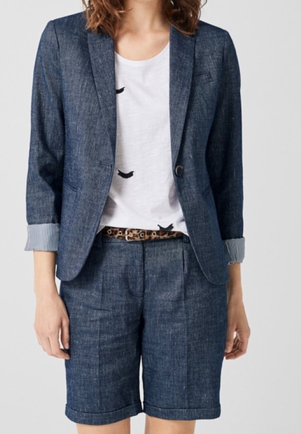 Jeansblazer med hakkkrage och uppvikta ärmslut, kombinerad med jeansshorts. Vit t-shirt med svart fågeltryck under, åtdragen med ett leopardmönstrat bälte.