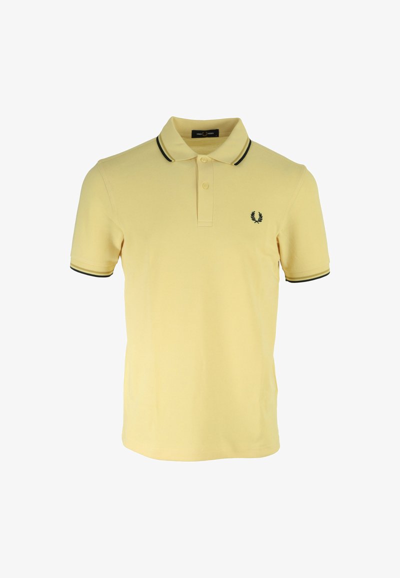 Polo amarillo de algodón, con un cuello ribeteado en negro, tapeta de dos botones y un pequeño logo bordado en el pecho.