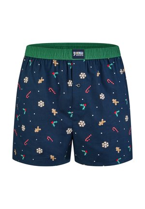 Marineblauwe boxershorts met een groene elastische tailleband, versierd met een feestelijk patroon van peperkoekmannetjes, sneeuwvlokken, zuurstokken, hulst en kleine stippen.