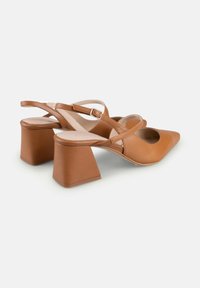Pantofi cu toc slingback din piele foarte deschisa, cu vârful ascuțit, având un toc pătrat gros și curele încrucișate pentru un fit sigur. Textură netedă.