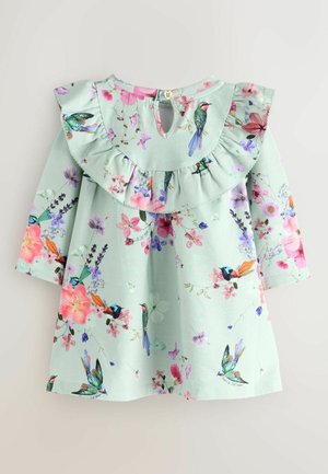 Lys grøn kjole med en volangkrave, prydet med et blomstermønster og fugle i pink, lilla og blå. Inkluderer knaplukning bagpå.