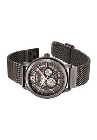 Montre ronde en acier inoxydable noir avec un cadran transparent, des accents en or rose et un bracelet en maille métallique noire, mettant en avant la mécanique exposée.