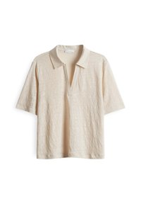 Polo shirt beige clair en tissu texturé, avec des manches courtes, un col classique et une fermeture éclair half devant.